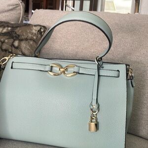 Selling a teal bluish bag can be used as a shoulder bag or as a bag to hold